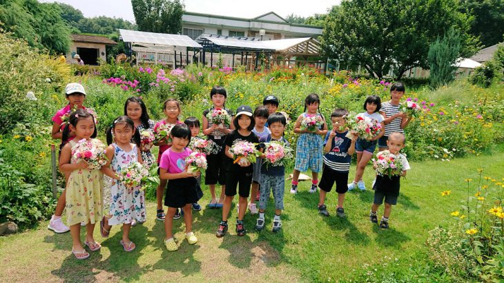 自分で作ったフラワーアレンジメントを抱える小学生たち